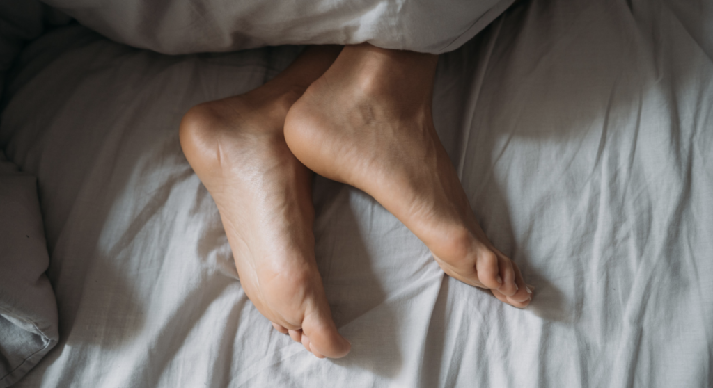 Feet resting comfortably on a bed after a relaxing foot massage in Campbell