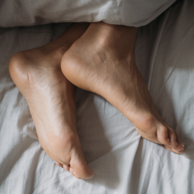 Feet resting comfortably on a bed after a relaxing foot massage in Campbell